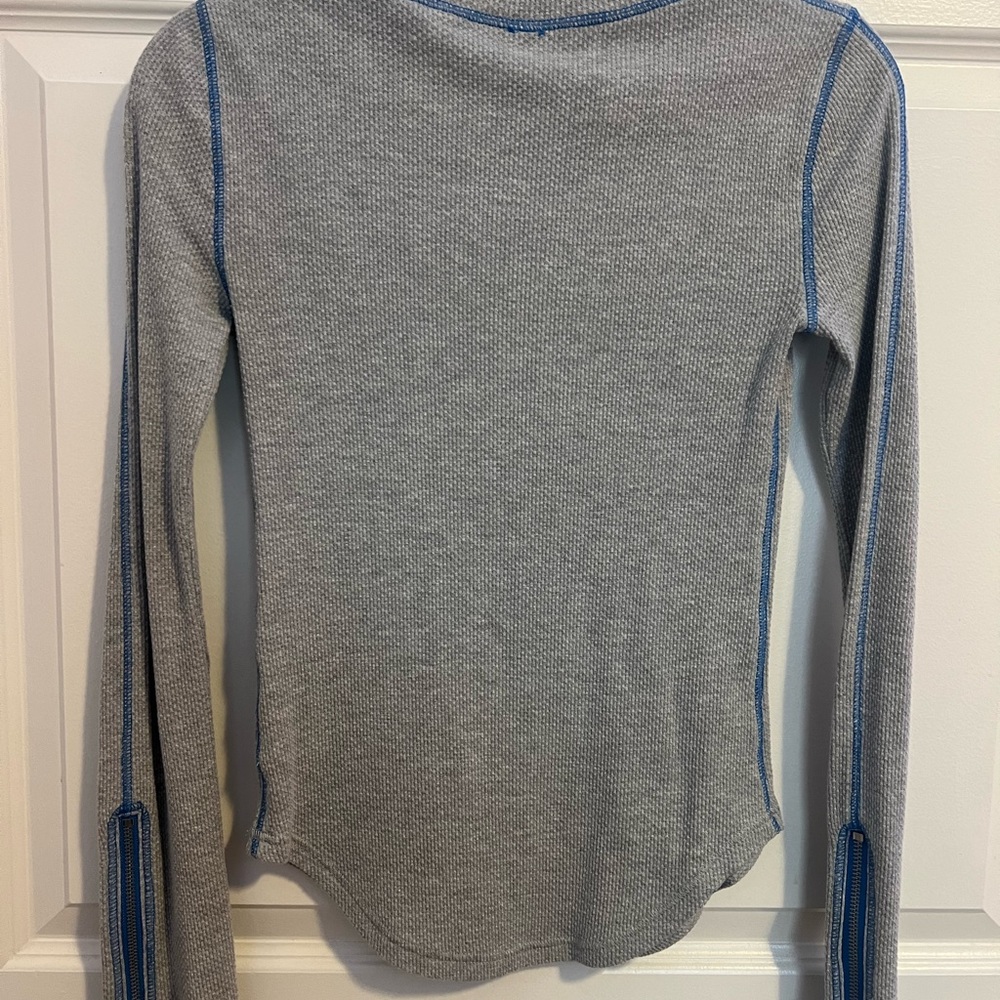 Free People gray textured top with blue stitching and zipper sleeves